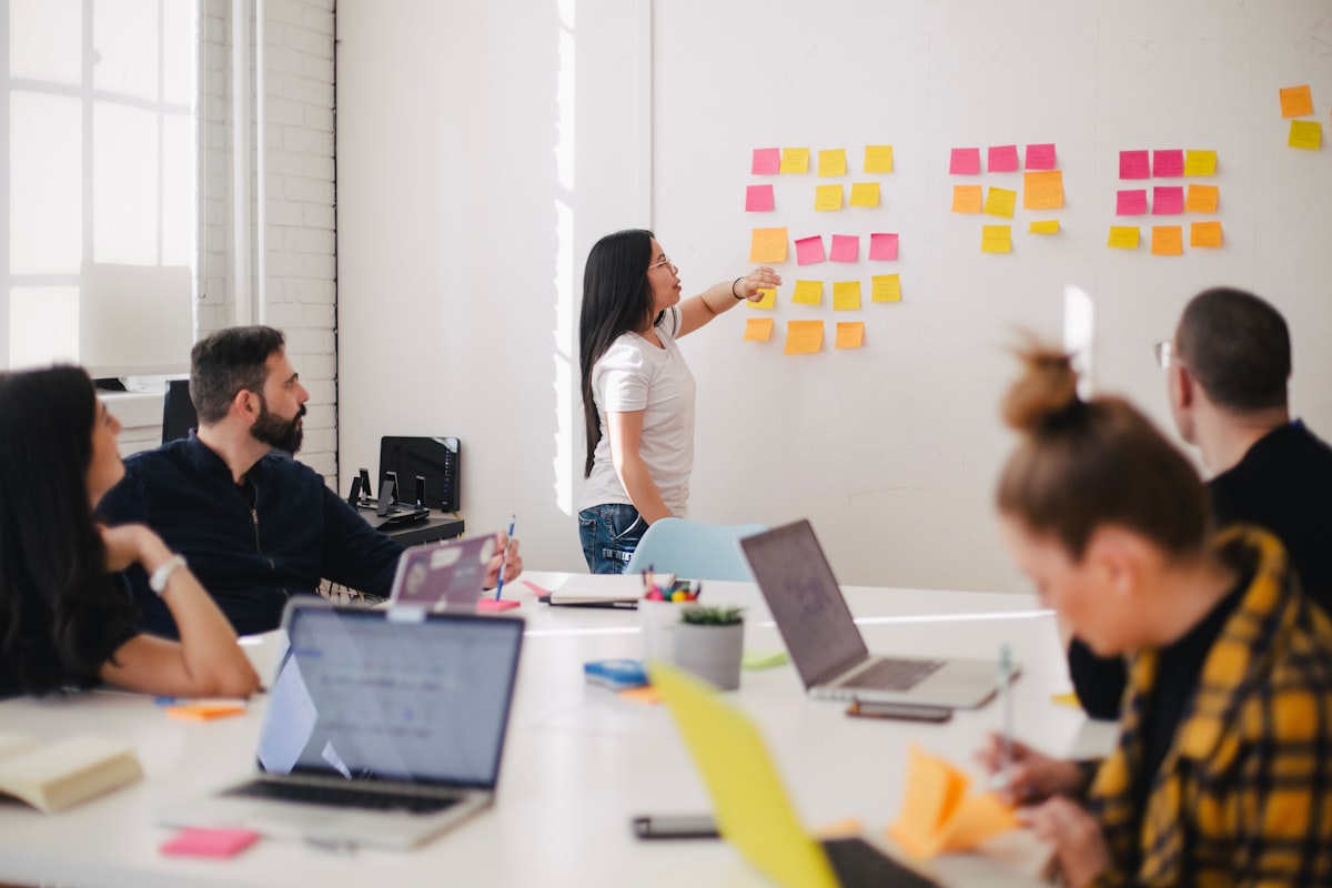 A manager mapping out departments on a wall of sticky notes